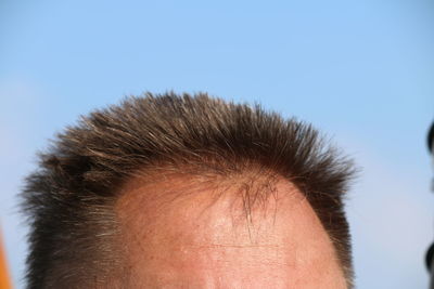 Close-up of man head against clear sky