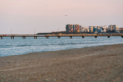 Bridge over sea against sky in city