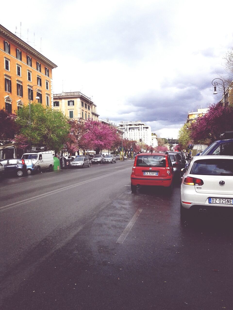 transportation, car, land vehicle, building exterior, mode of transport, street, architecture, road, built structure, sky, city, the way forward, road marking, traffic, city street, tree, cloud - sky, diminishing perspective, building, parking