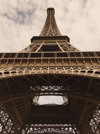 Low angle view of eiffel tower against cloudy sky