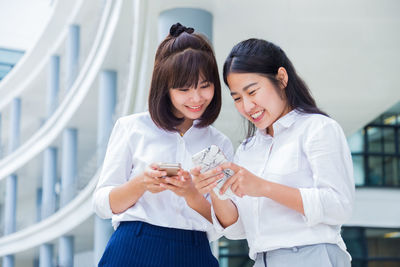 Smiling young woman using mobile phone