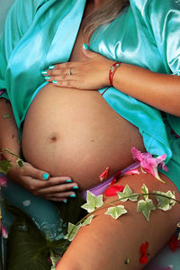 Midsection of pregnant woman with hands on stomach