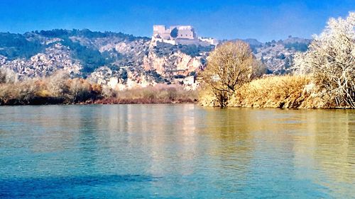 Scenic view of lake and trees against blue sky