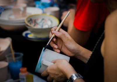 Midsection of woman holding hands on table