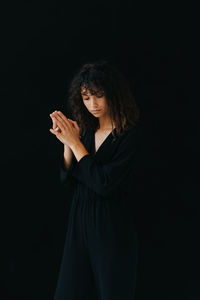 Woman standing against black background