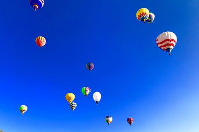 Low angle view of hot air balloons against blue sky