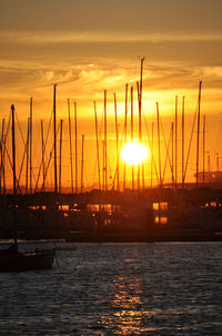 Boats in sea at sunset