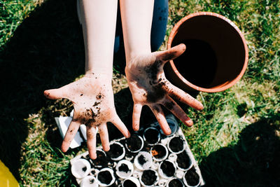 Childs dirty hands from planting seeds in egg shells outside