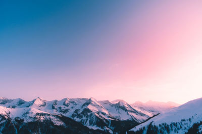 Scenic view of snowcapped mountains against sky during sunset