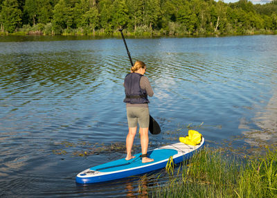 Rear view of woman in boat in lake