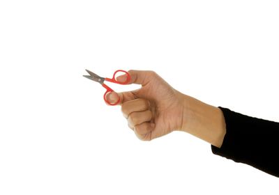 Close-up of hand holding paper over white background