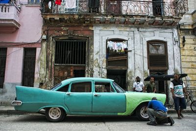 Vintage car on street against buildings in city