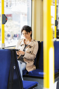 Woman using cellphone in tram