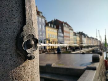 Close-up of rusty metal by river against sky