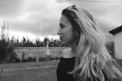 Portrait of woman looking away against sky