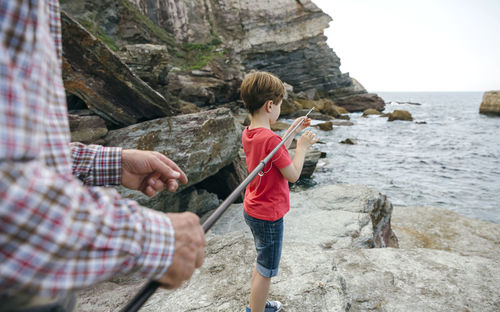 Grandfather and grandson fishing together at the sea