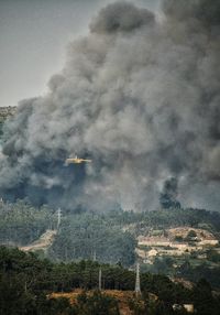 Low angle view of airplane flying over landscape against sky