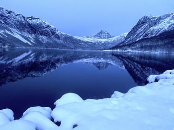 Scenic view of lake and snowcapped mountains against sky