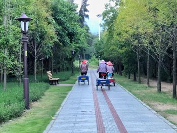 Rear view of people walking on footpath