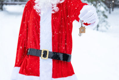 Midsection of woman standing on snow covered field