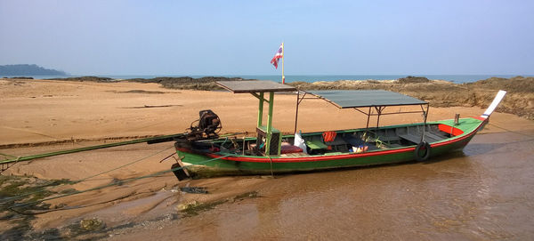 Ship moored on beach against clear sky