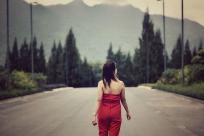 Rear view of woman walking on road