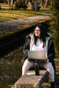 Young woman sitting on mobile phone