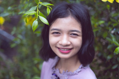 Portrait of smiling teenage girl standing outdoors