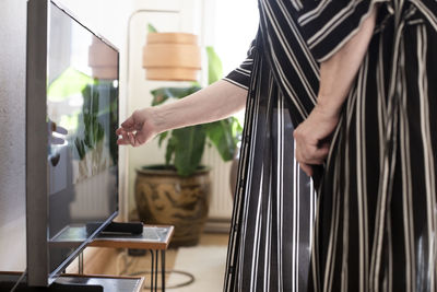 Woman touching lcd television at home