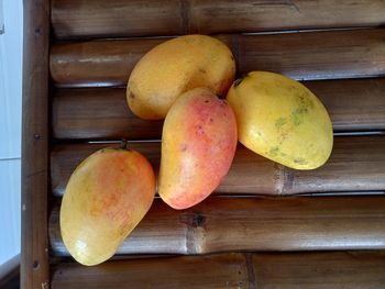 High angle view of mangoes in container on wooden table