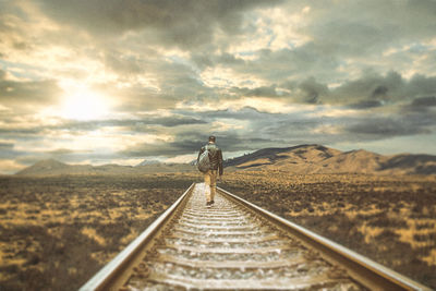 Rear view of man standing on railroad track