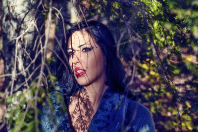 Close-up of woman looking away in forest