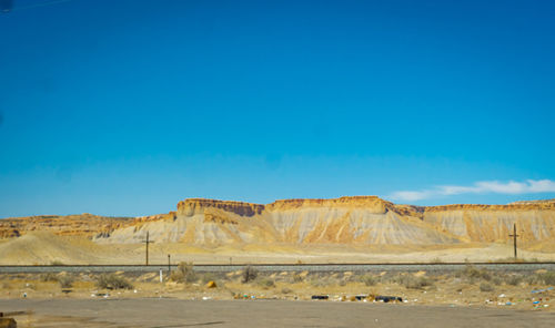 Scenic view of desert against blue sky