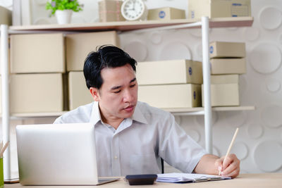 Man using mobile phone while sitting on table