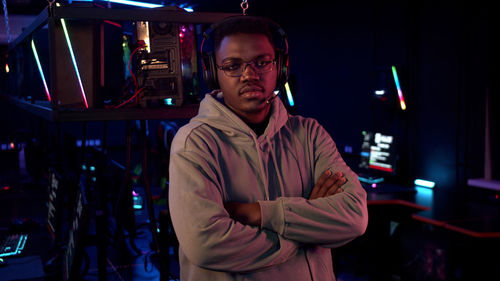 Portrait of young man standing in internet cafe