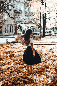 Rear view of woman standing against trees