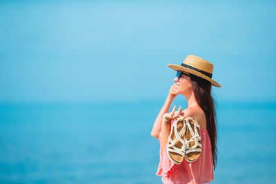 Woman standing by sea against sky