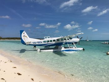 Airplane on beach against sky