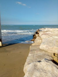 Rocks on beach against sky