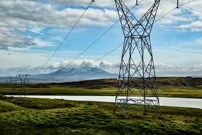 Electricity pylon on land against sky