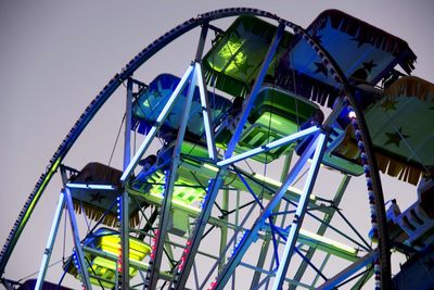 Low angle view of illuminated ferris wheel against clear sky