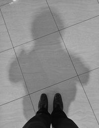 Low section of man standing on tiled floor