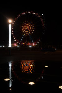 Illuminated ferris wheel at night