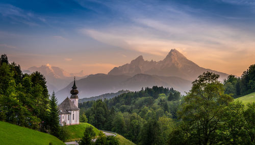 Scenic view of trees and mountains against sky during sunset