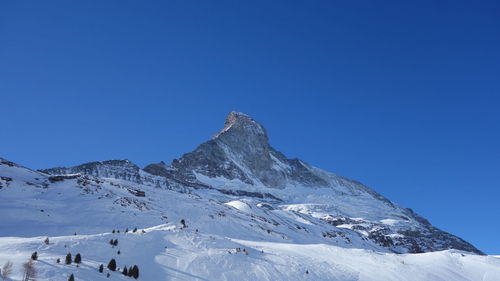 Scenic view of snowcapped mountains against clear blue sky