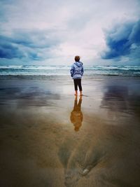 Rear view of girl standing on beach