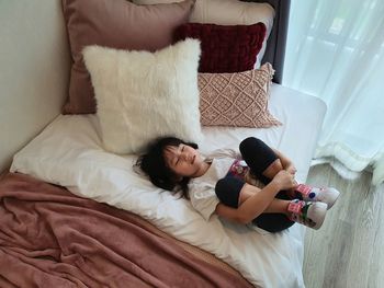 High angle view of women relaxing on bed at home