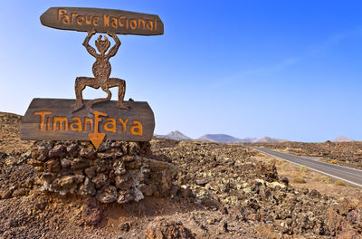 Information sign on road against clear blue sky