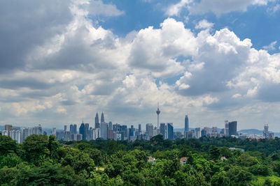 Scenic view of trees and buildings against sky