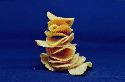 Close-up of yellow cake on table against blue background